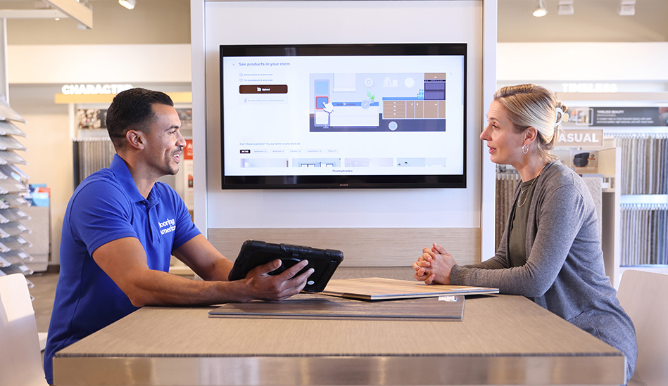 woman looking at flooring samples in a showroom with flooring expert