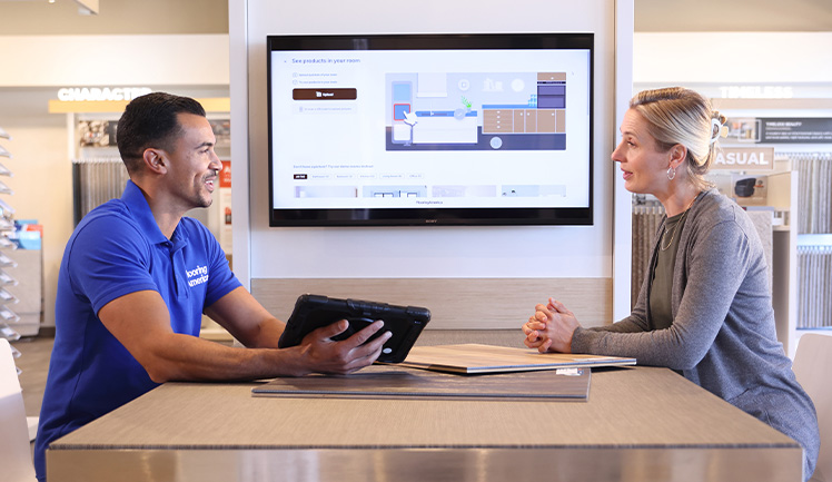 woman looking at flooring samples in a showroom with flooring expert